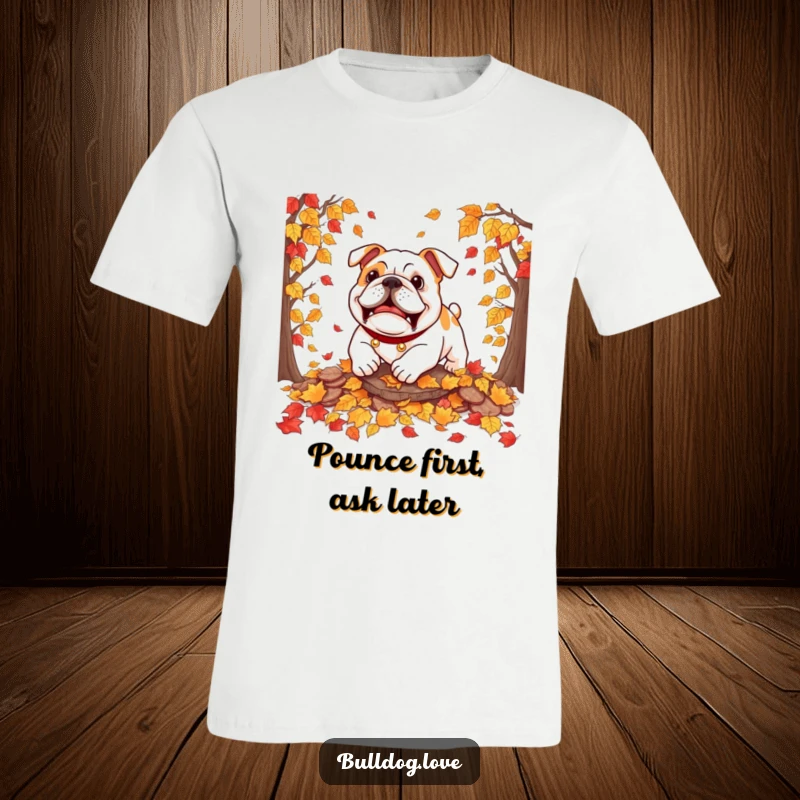 Funny bulldog t-shirt depicting a dog playfully pouncing into a pile of rustling autumn leaves, embodying seasonal fun.