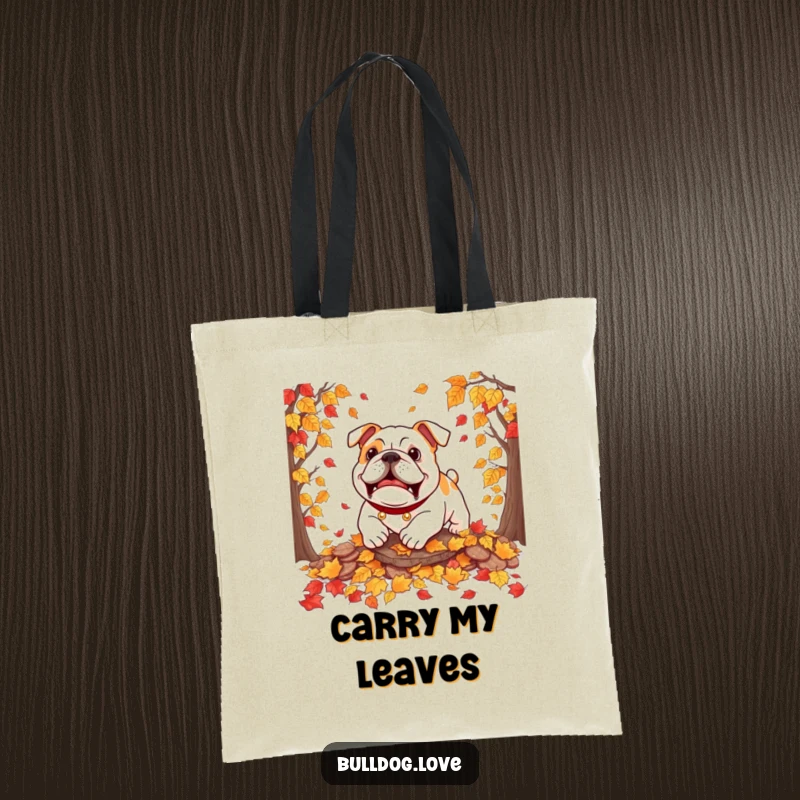 Funny bulldog tote bag showing a dog playfully pouncing into a heap of rustling autumn leaves, full of seasonal delight.